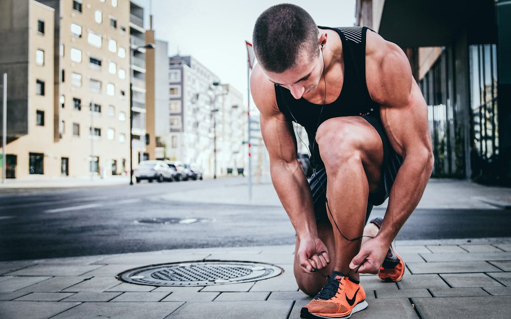 Runner preparing shoes outdoors for cardiovascular endurance session